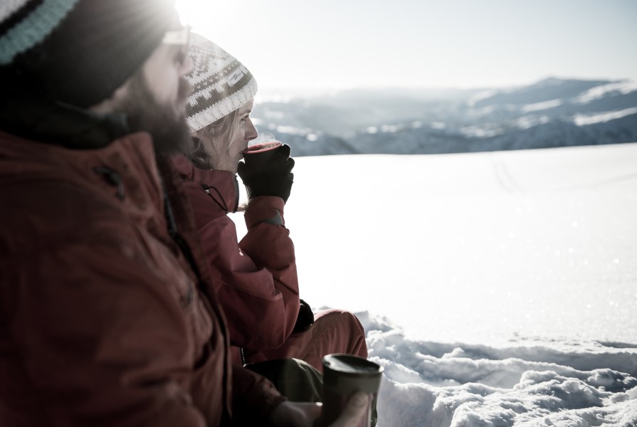 Ein mann og ei kvinne drikk kaffi på skitur i Myrkdalen